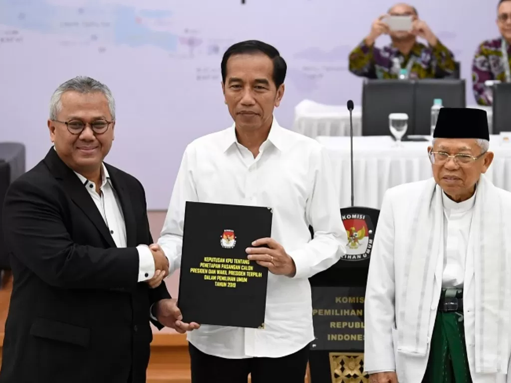 Ketua KPU Arief Budiman (kiri) menyerahkan surat keputusan KPU tentang Penetapan Hasil Pemilu 2019 kepada Presiden dan Wakil Presiden terpilih periode 2019-2024, Joko Widodo (tengah) dan KH Ma'ruf Amin (kanan). (Antara/Puspa Perwitasari)