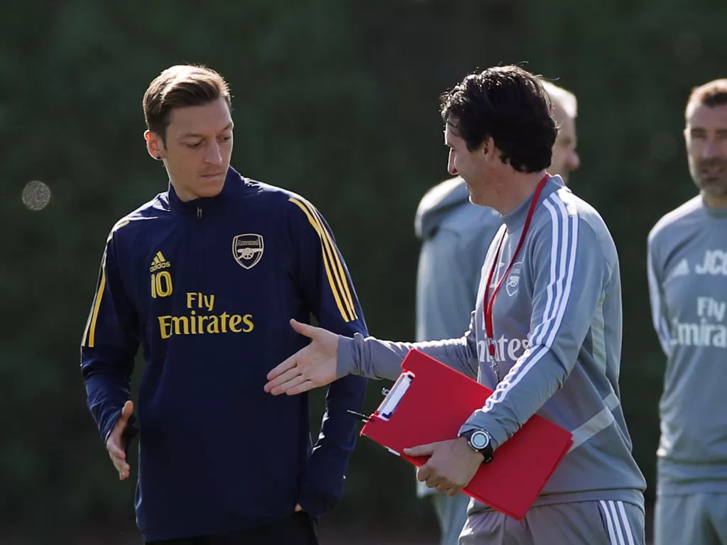 Mesut Ozil (kanan) bersama Unai Emery ketika sesi latihan (Reuters/Paul Childs).
