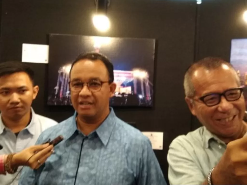 Gubernur DKI Jakarta Anies Baswedan (tengah) bersama fotografer senior Arbain Rambey (kanan) memberikan pernyataan pada awak media usai acara pameran foto ruang ketiga di Balai Kota Jakarta, Sabtu (19/10). (Antara/Ricky Prayoga)