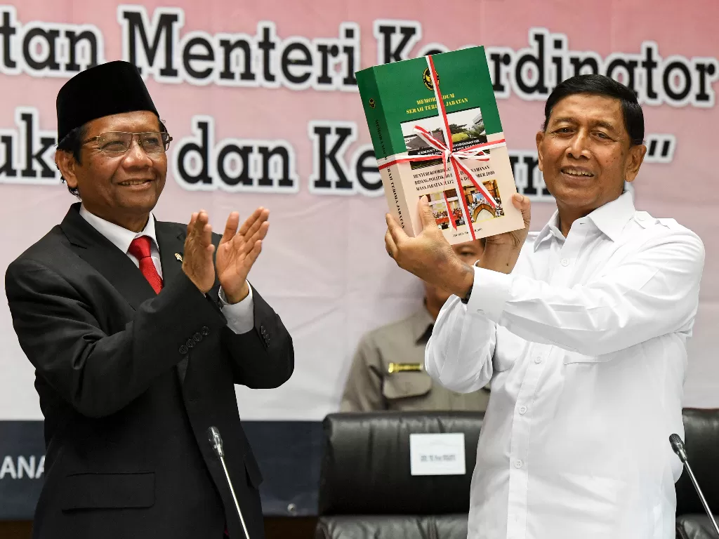 Menkopolhukam Mahfud MD (kiri) bersama Wiranto saat serah terima jabatan di Kantor Kemenkopolhukam, Jakarta, Rabu (23/10). (Antara/Hafidz Mubarak A)