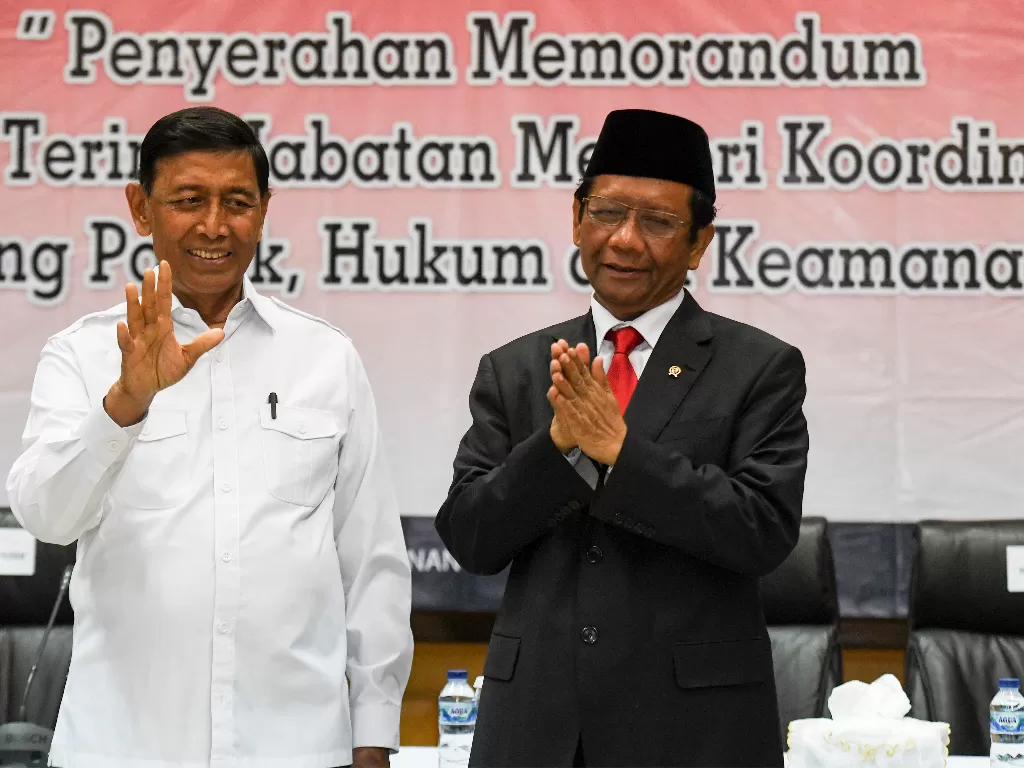 Menko Polhukam Mahfud MD (kiri) bersama mantan Menko Polhukam Wiranto (kanan) mengikuti serah terima jabatan di kantor Kemenko Polhukam, Jakarta, Rabu (23/10/2019). (ANTARA FOTO/Hafidz Mubarak A/foc).