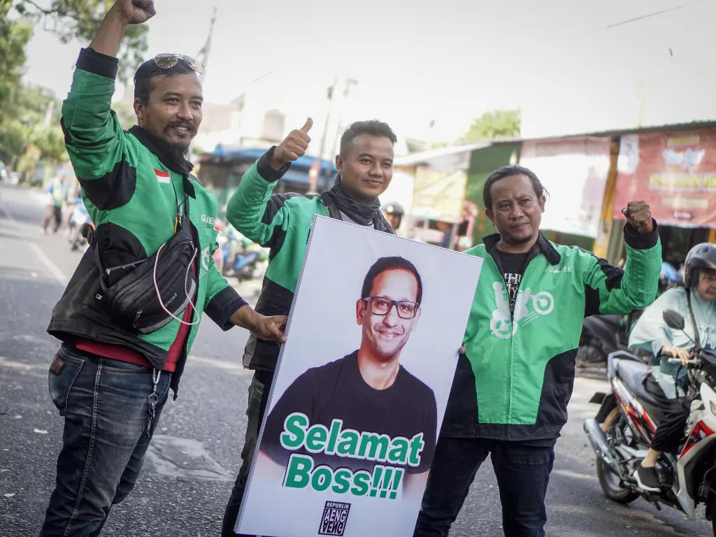 Pengemudi ojek online Gojek membawa poster ucapan selamat kepada Pendiri dan CEO Gojek Nadiem Makarim di Solo, Jawa Tengah, Rabu (23/10/2019).(ANTARA FOTO/Mohammad Ayudha/ama)