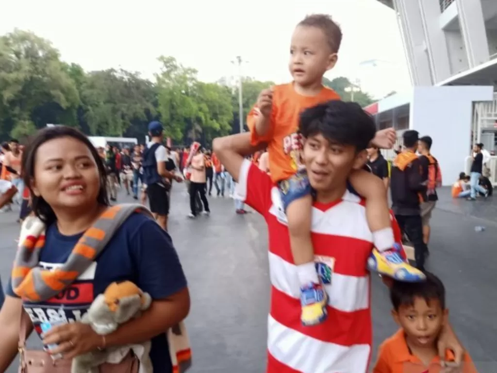 Suporter sepakbola The Jak Mania membawa keluarganya menyaksikan laga pertandingan Persija-Persib di Stadion Utama Gelora Bung Karno, Jakarta, Rabu (10/7). Antara/ Zubi Mahrofi