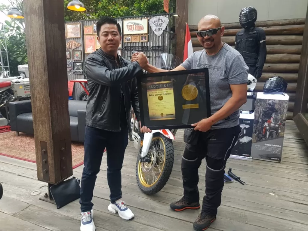 Jeffrey Polnaja (kanan) menerima Rekor Otomotif Indonesia (ROI) sebagai 'Penjelajah Motor Indonesia dengan Jarak Tempuh Terjauh 420.000 Kilometer'. (ROI)