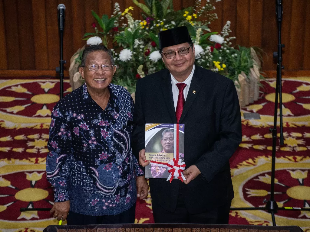 Menko Perekonomian Airlangga Hartarto (kanan) menerima buku memori jabatan Menko Perkonomian dari pejabat lama Darmin Nasution, dalam serah terima jabatan di Kantor Kemenko Perekonomian, Jakarta, Rabu (23/10/2019). (ANTARA FOTO/Aprillio Akbar/ama)