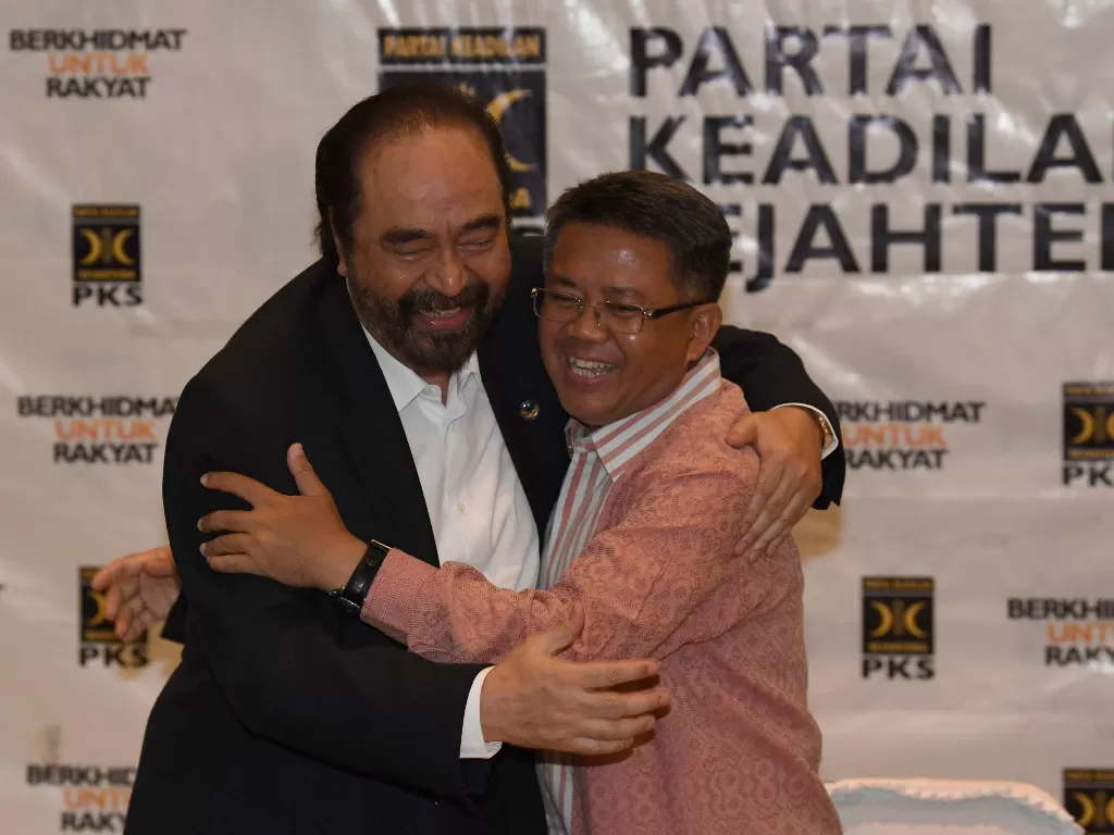 Ketua Umum Partai Nasdem, Surya Paloh (kiri) berpelukan dengan Presiden PKS, Sohibul Iman, setelah menyampaikan hasil pertemuan tertutup antara kedua partai (Antara/Puspa Perwitasari).