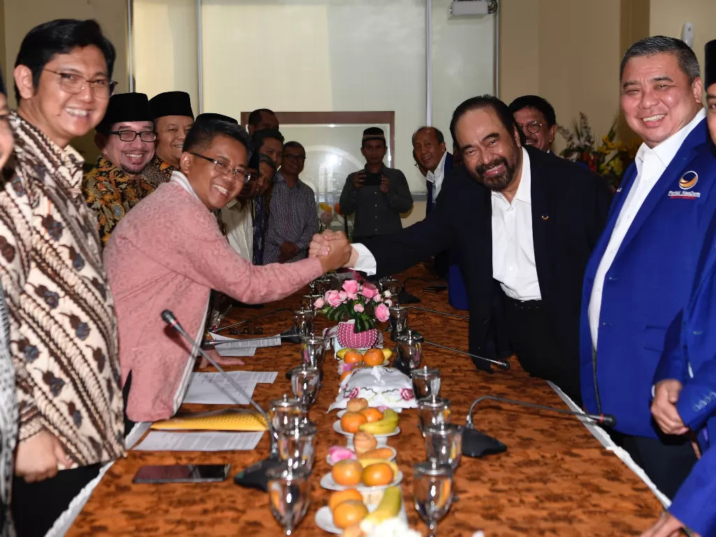 Ketum Partai Nasdem Surya Paloh (ketiga kanan) berjabat tangan dengan Presiden PKS Sohibul Iman (ketiga kiri) saat pertemuan di DPP PKS, Jakarta, Rabu (30/10). (Antara/Puspa Perwitasari)