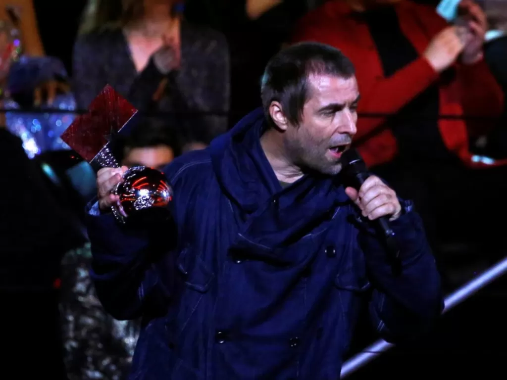 Liam Gallagher bersama penghargaan yang diterimanya. (Reuters/Marcelo Del Pozo)