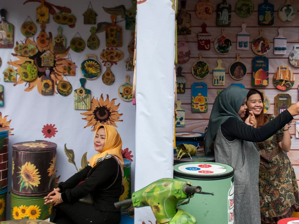 Pengunjung berswafoto pada salah stan kerajinan pada pameran Pekan Kerajinan Jawa Barat 2019 di depan Gedung Sate, Bandung, Jawa Barat, Jumat (25/10/2019).(ANTARA FOTO/Novrian Arbi/nz).