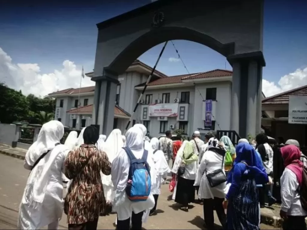 Jamaah yang akan mengikuti sidang gugatan perdata aset First Travel memasuki gedung pengadilan Negeri Depok, Jawa Barat, Rabu (20/3). (Antara/Kahfie Kamaru)