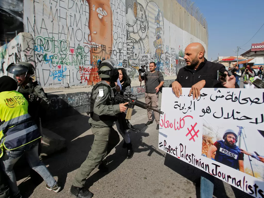 Aksi wartawan palestina yang dipaksa mundur oleh militer Zionis Israel. (Reuters/Mussa Qawasma)