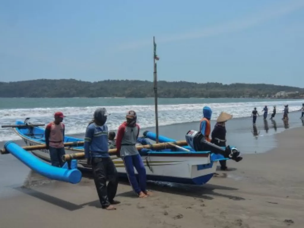 Sejumlah nelayan bergotong royong mendorong perahu berkapasitas tujuh Gross Tonnage (GT) di Pesisir Pantai Timur Pangandaran, Jawa Barat, (Antara/Adeng Bustomi)