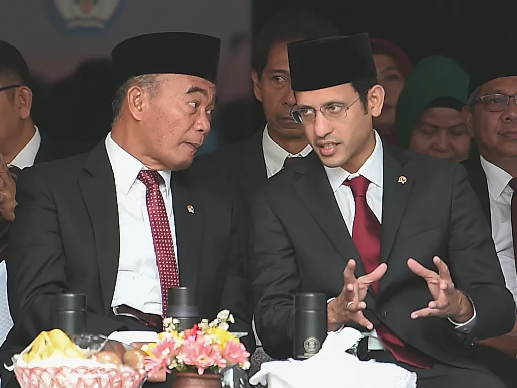 Mendikbud Nadiem Makarim (kanan) berbincang dengan Menko PMK Muhadjir Effendy saat menghadiri upacara peringatan Hari Guru Nasional 2019, Senin (25/11/2019). (Antara/Nova Wahyudi)