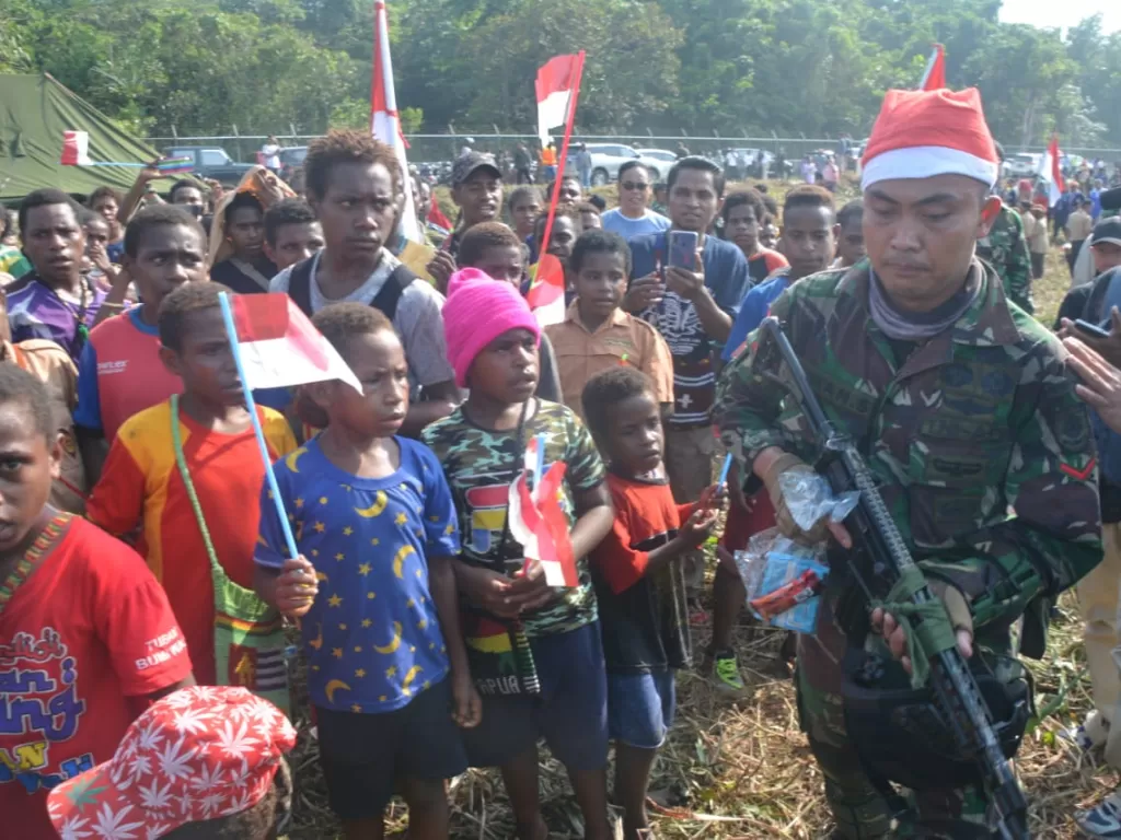 Prajurit TNI dengan topi khas Sinterklas saat disambut anak-anak Timika. (Puspen TNI)