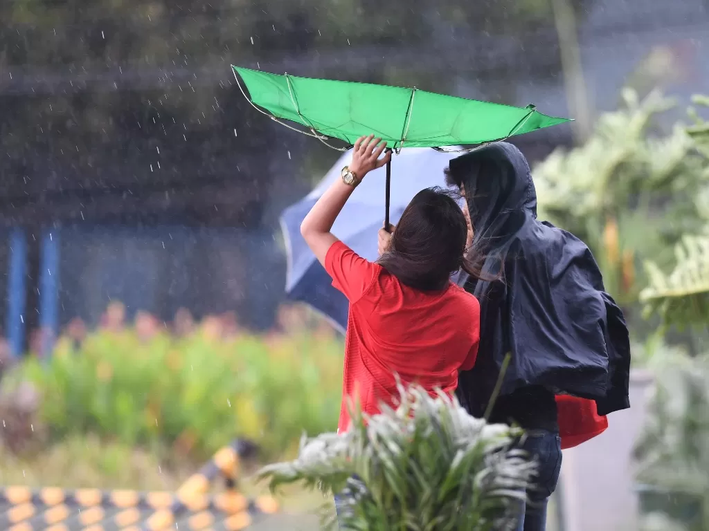 Petugas SEA Games memperbaiki payungnya yang diterjang angin saat terjadinya badai Kammuri yang melanda arena SEA Games ke-30 di kawasan World Trade Center Manila, Filipina, Selasa (3/12). ANTARA FOTO/Nyoman Budhiana