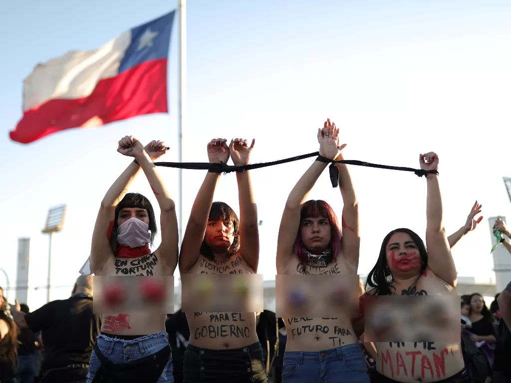  Sejumlah aktivis wanita mengangkat tangan mereka yang diikat saat mengikuti protes menentang kekerasan terhadap perempuan dan terhadap pemerintah Chili di Santiago, Chili, 4 Desember 2019. REUTERS / Pablo Sanhueza