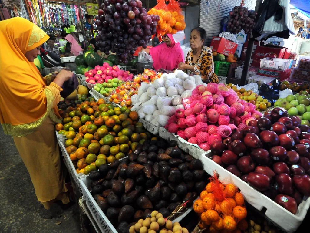 Pedagang dan pembeli buah bertransaksi di Pasar Kolpajung, Pamekasan, Jawa Timur, Jumat (8/11). Saat ini hasrat belanja masyarakat kian meningkat (Antara/Saiful Bahri).