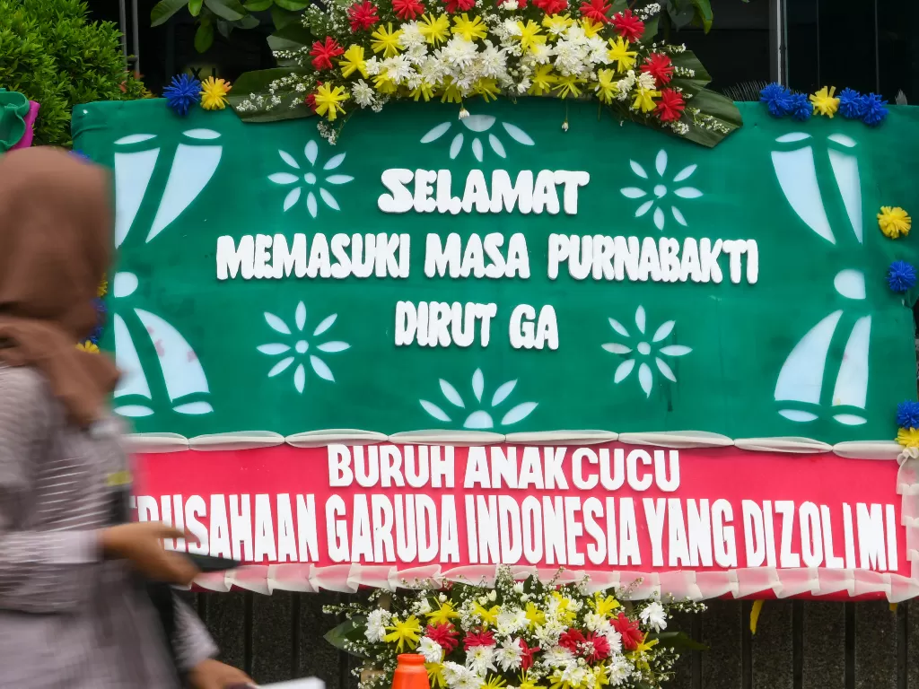 Warga melintasi karangan bunga ucapan terima kasih hingga dukungan kepada Menteri BUMN di halaman Kementerian BUMN Jakarta, Jumat (6/12). ANTARA FOTO/Nova Wahyudi