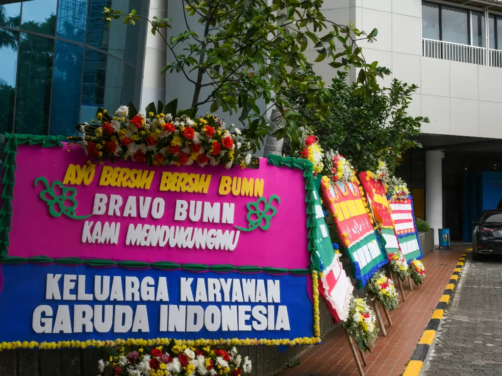 Warga mengabadikan karangan bunga ucapan terima kasih hingga dukungan kepada Menteri BUMN di halaman Kementerian BUMN, Jumat (6/12). (Antara/Nova Wahyudi)