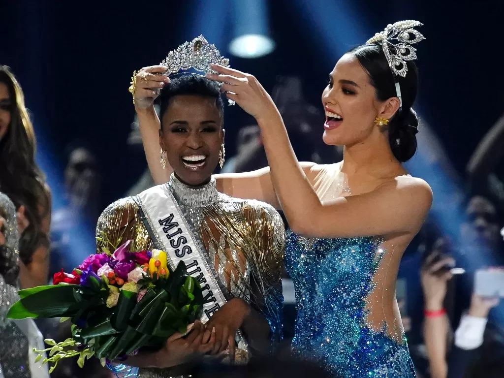 Miss Universe 2018 Catriona Gray menyematkan mahkota kepada Miss Afrika Selatan, Zozibini Tunzi menjadi Miss Universe 2019 pada malam final di Tyler Perry Studios, Atlanta, Georgia, Amerika Serikat, Minggu, 8 Desember 2019. REUTERS / Elijah Nouvelage