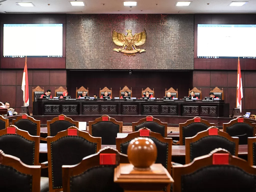 Ketua Hakim MK, Anwar Usman (tengah) membacakan amar putusan soal gugatan koruptor ikut Pilkada di Gedung Mahkamah Konstitusi, Jakarta, Rabu (11/12). (Antara/Hafidz Mubarak A)