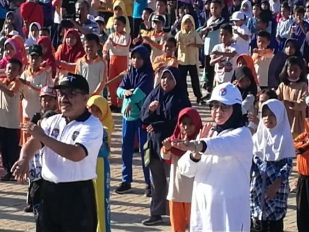Bupati Wakatobi Ahrawi (kiri) dan Sekretaris Deputi Pembudayaan Olahraga Kemenpora Suryati (kanan) melakukan gerakan senam dalam Festival Senam Kebugaran Jasmani (SKJ) di Pantai Marina, Wangi-Wangi, Wakatobi, Minggu (15/12). (Antara/Gilang Galiartha)