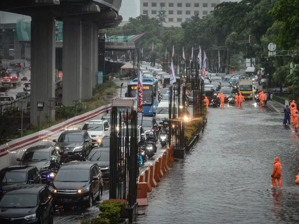 Kendaraan melintas di samping genangan air di Jalan HR Rasuna Said, Kuningan, Jakarta, Selasa (17/12). (Antara/Jaya Kusuma)