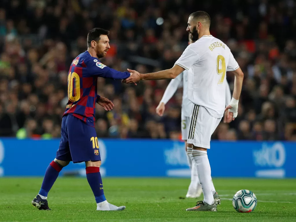 Penyerang Barcelona Lionel Messi bersalaman dengan penyerang Real Madrid Karim Benzema dalam pertandingan Liga Spanyol di Camp Nou, Spanyol, 19 Desember 2019. REUTERS/Albert Gea