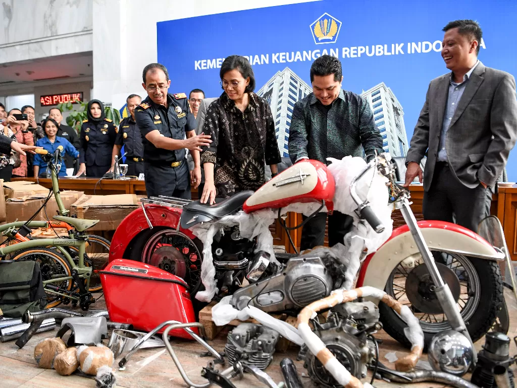 Menteri Keuangan Sri Mulyani (kedua kiri) bersama Menteri BUMN Erick Thohir (kedua kanan)  melihat barang bukti motor Harley Davidson dan sepeda Brompton. (Antara/Hafidz Mubarak)