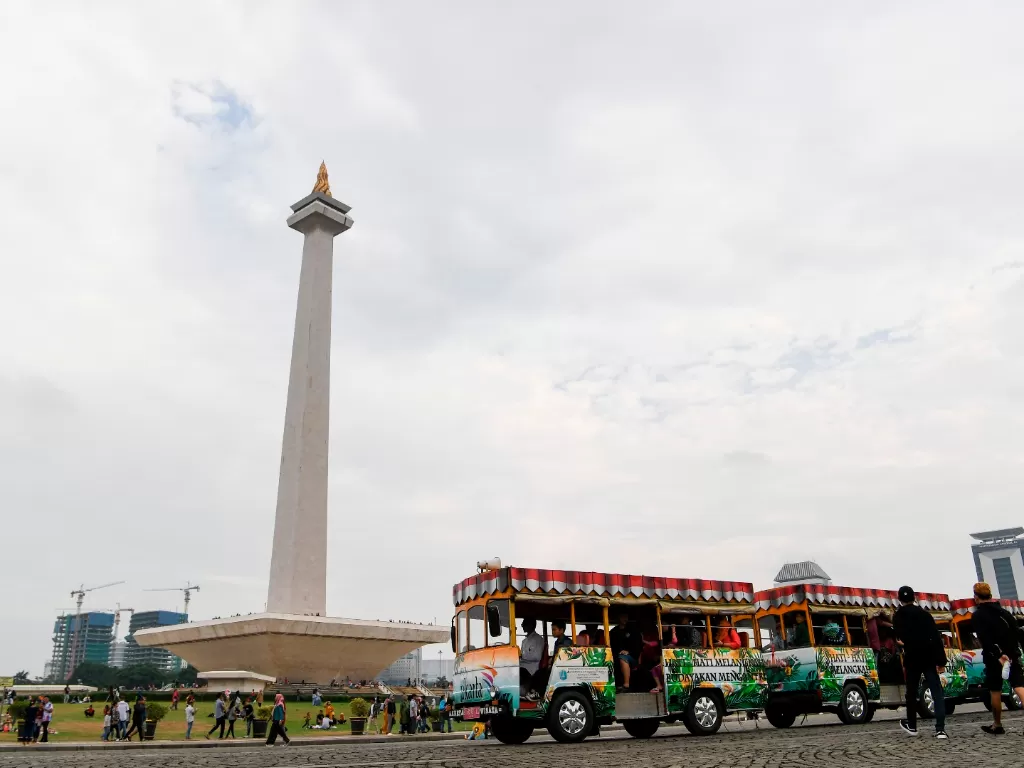 Pengunjung menaiki kereta wisata saat berkunjung ke kawasan Monumen Nasional (Monas) di Jakarta, Rabu (25/12/2019). photo/ANTARA FOTO/Hafidz Mubarak A