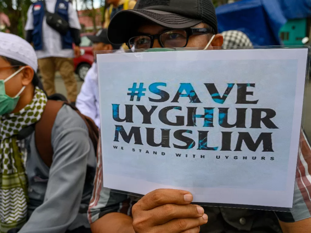 Aktivis Forum Umat Islam (FUI) Sulawesi Tengah membawa poster saat berunjuk rasa terkait Muslim Uighur di depan Kantor DPRD Sulawesi Tengah di Palu, Jumat (20/12). (Antara/Basri Marzuki)