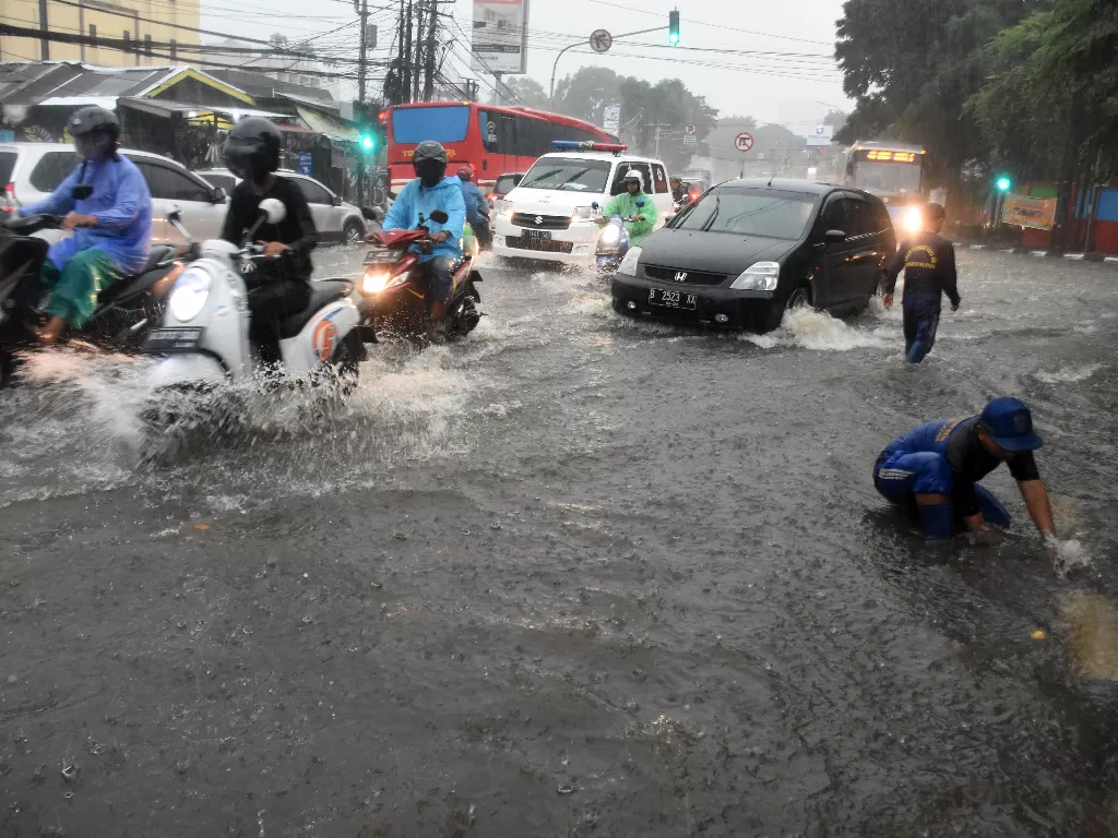 Petugas Suku Dinas Sumber Daya Air Jakarta Selatan mengecek saluran air saat banjir di kawasan Kalibata, Jakarta, Jum'at (27/12/2019). (ANTARA FOTO/Indrianto Eko Suwarso/aww).