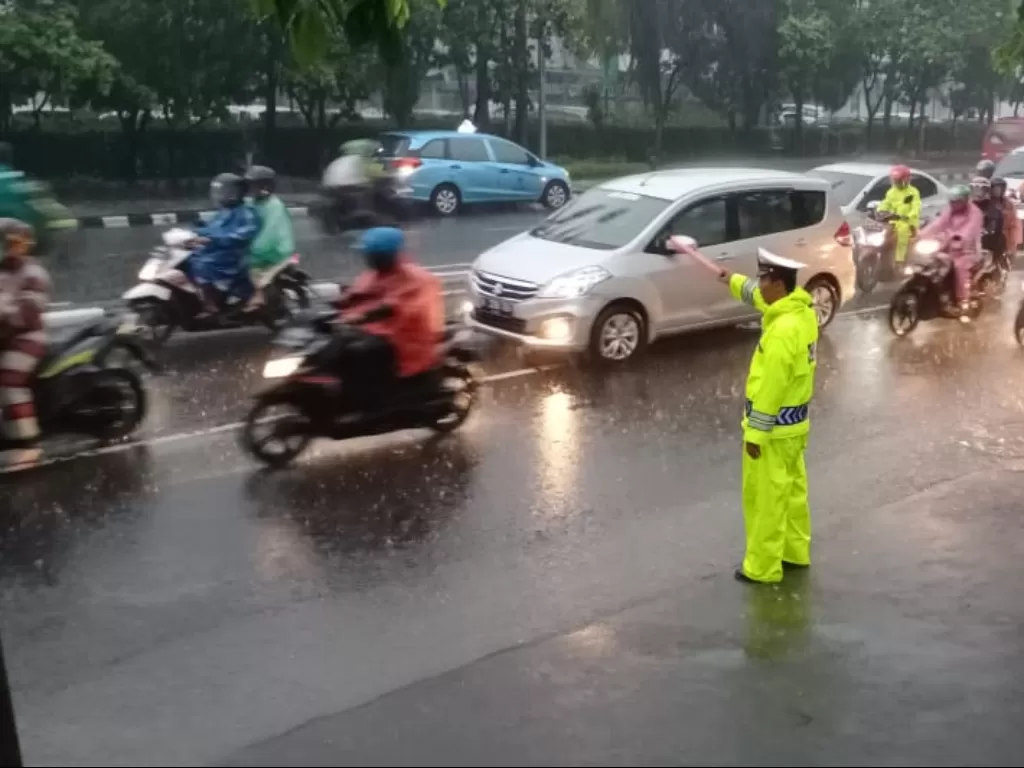 Anggota Sat Lantas Jaktim mengatur lalulintas di sekitar Tamini Square arah Pasat Rebo dan Pondok Gede yang terpantau ramai lancar di tengah cuaca hujan. (Twitter/@TMCPoldaMetroJaya)