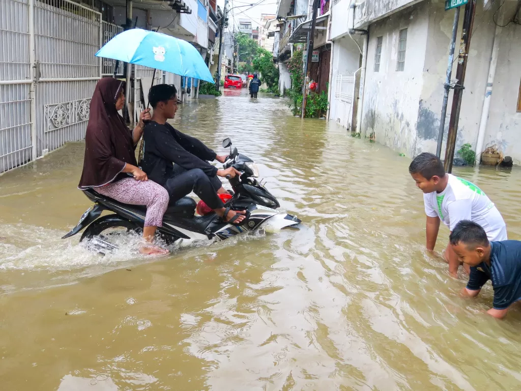 Sejumlah anak bermain saat banjir di kawasan Pasar Baru, Jakarta Pusat, Rabu (1/1/2020). Menurut warga banjir mulai merendam areal perumahan sekitar pukul 04.00 WIB. (ANTARA FOTO/M Risyal Hidayat/foc).