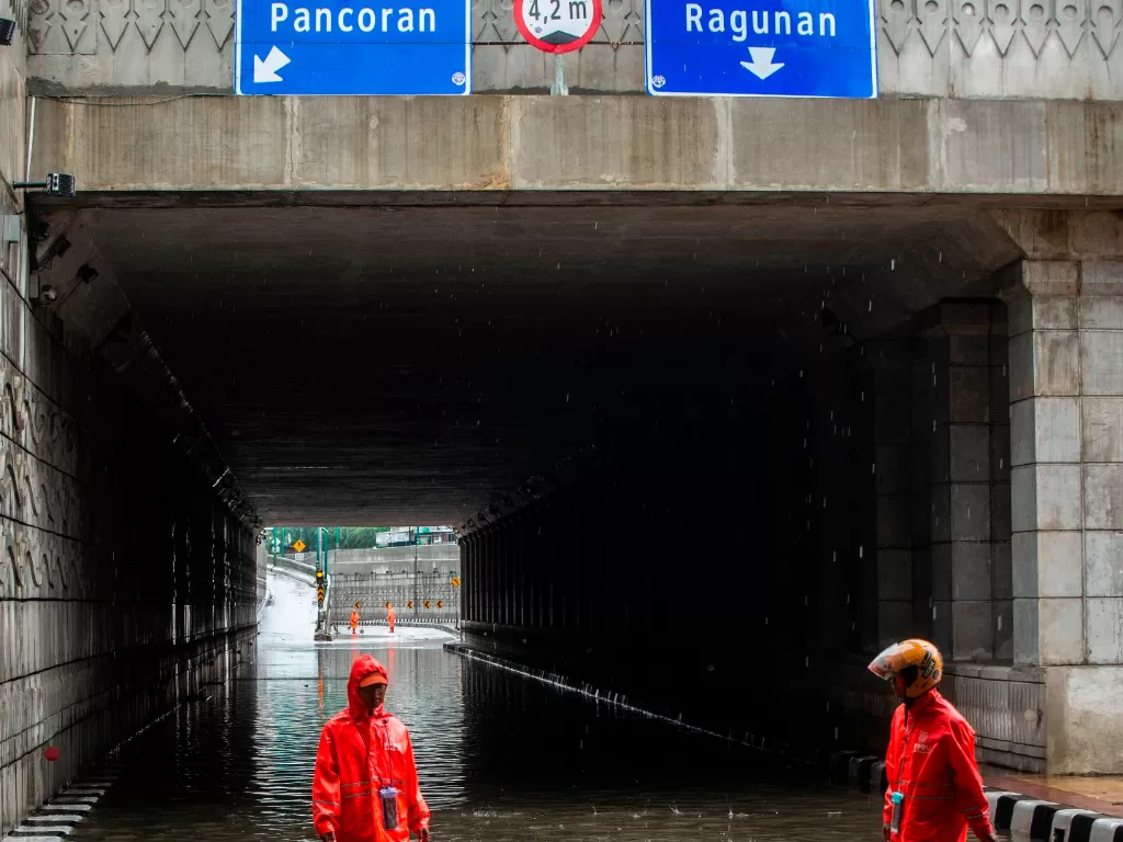 Petugas PPSU memberishkan sampah saat terjadi genangan banjir di Underpass Mampang-Kuningan, Jakarta, Rabu (1/1/2020). Banjir tersebut disebabkan karena tingginya intensitas hujan yang mengguyur sejak Selasa (31/12/2019). (ANTARA FOTO/Aprillio Akbar/foc).