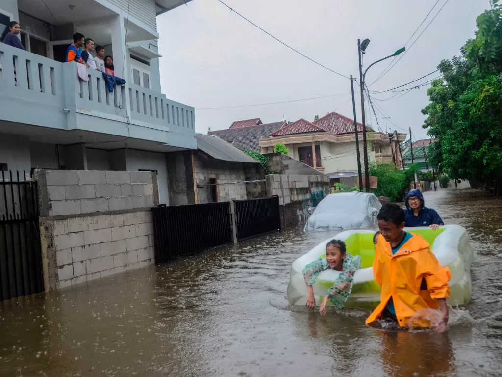 Sejumlah anak bermain menggunakan perahu saat banjir di Duren Sawit, Jakarta Timur, Rabu (1/1/2020). Menurut warga banjir mulai merendam areal sekitar perumahan pada pukul 04.00 WIB. (ANTARA FOTO/ Fakhri Hermansyah/foc).