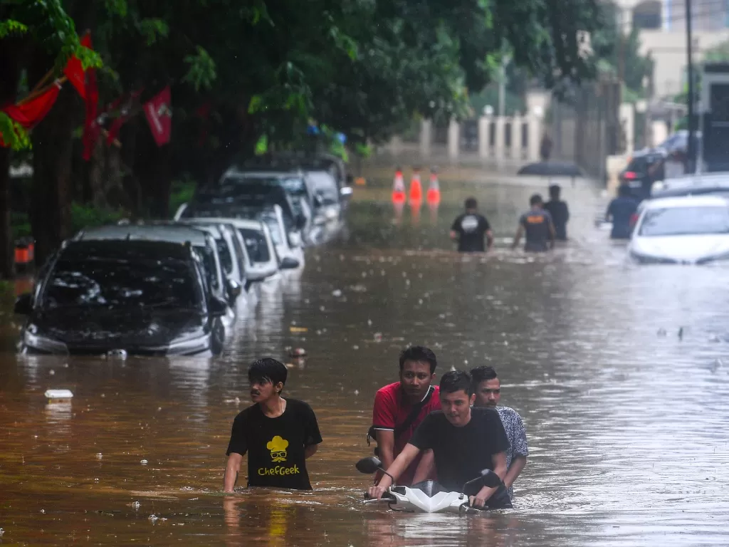 Warga mendorong sepeda motornya saat banjir menggenangi Jalan Taman Kemang, Jakarta Selatan, Rabu (1/1/2020). Hujan deras yang mengguyur DKI Jakarta membuat sejumlah wilayah di Ibu Kota terendam banjir. (ANTARA FOTO/Sigid Kurniawan/foc).