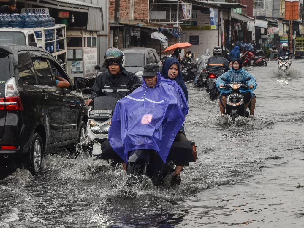 Sejumlah pengendara menerobos banjir yang menggenangi wilayah Pondok Ungu Permai, Kabupaten Bekasi, Jawa Barat, Senin (16/12/2019). Banjr diakibatkan tersumbatnya aliran Kali Busa. (ANTARA FOTO/Fakhri Hermansyah/aww).