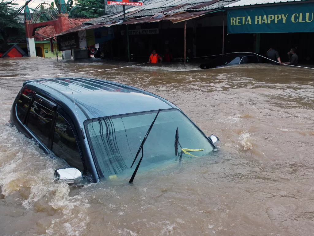  Mobil terendam banjir. (Antara/Muhammad Iqbal)