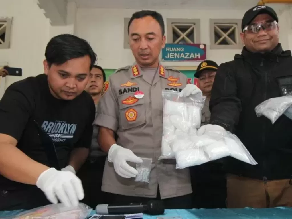 Polisi sedang menunjukkan barang bukti narkoba sabu-sabu seberat 1,5 kilogram serta 950 butir pil ineks dari seorang pengedar yang ditembak mati, Kamis (2/1). photo/Antara Jatim/ Didik Suhartono