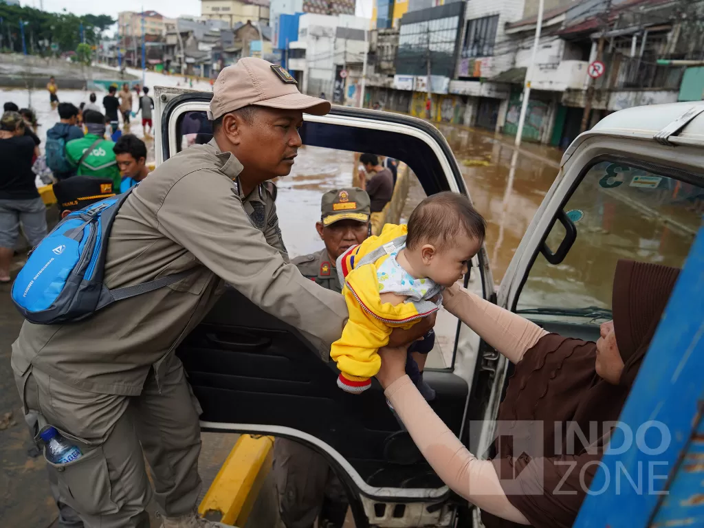 Petugas mengevakuasi warga saat banjir di Jalan Jatinegara Barat, Kampung Pulo, Jakarta, Kamis (2/1/2020). INDOZONE/Arya Manggala