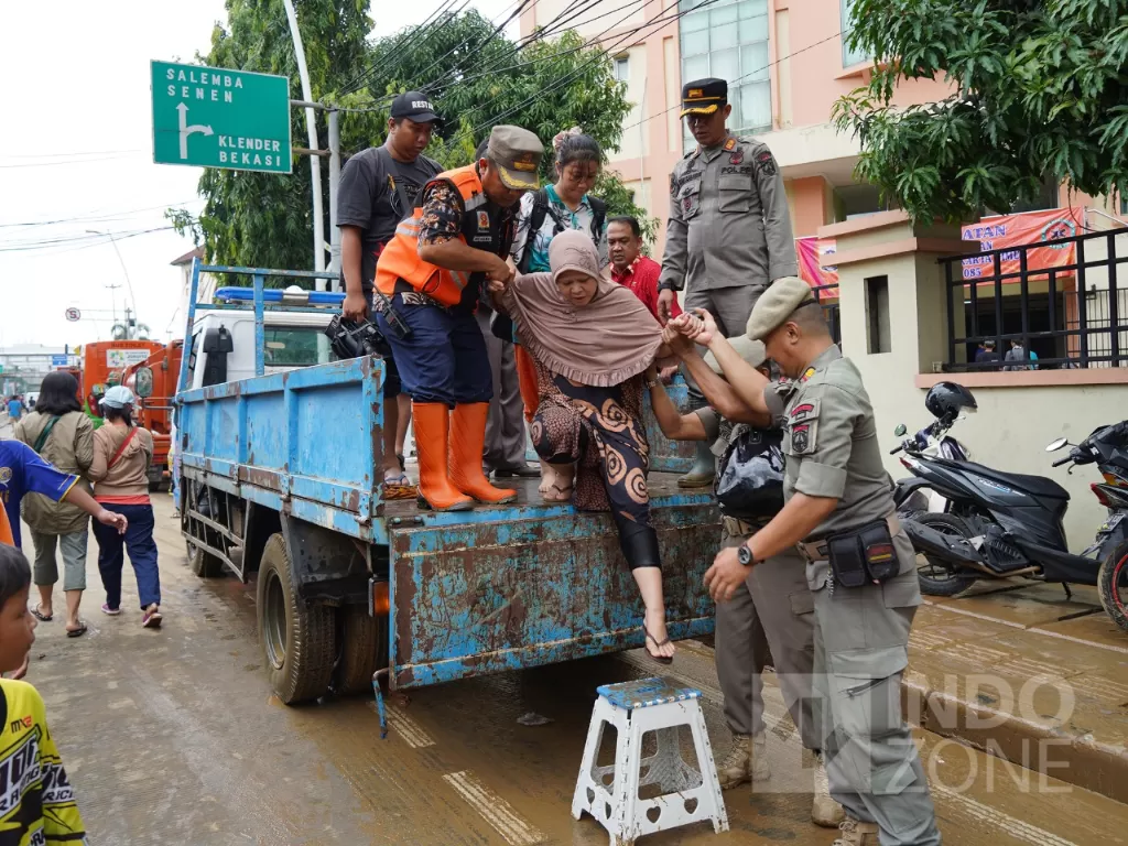 Petugas mengevakuasi warga saat banjir di Jalan Jatinegara Barat, Kampung Pulo, Jakarta, Kamis (2/1). (Indozone/Arya Manggala)