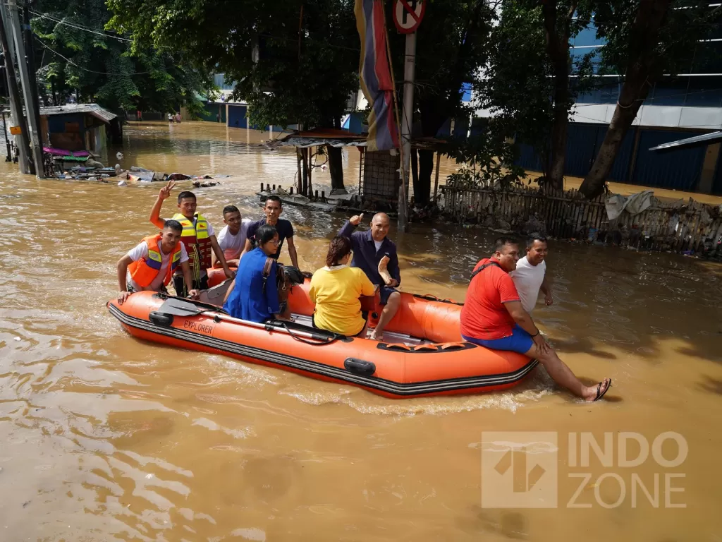 Petugas mengevakuasi warga saat banjir. (Indozone/Arya Manggala)