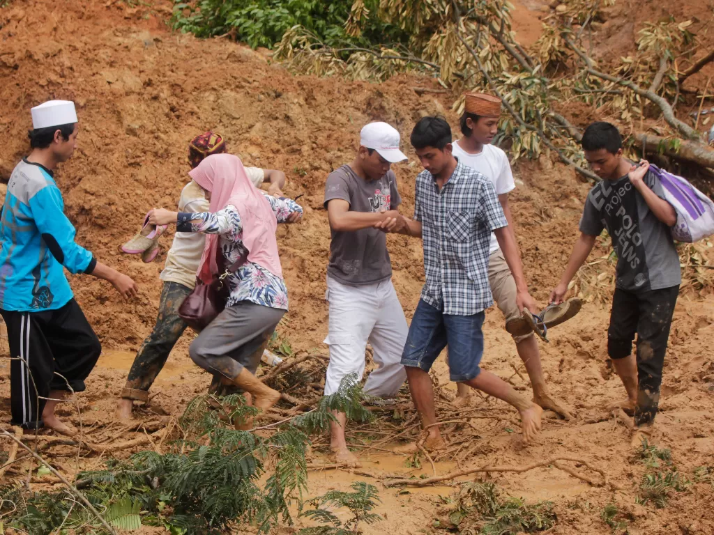 Relawan membantu Warga Kampung Muhara yang terisolir melewati lumpur saat akan mengungsi ke Kampung Lebak Gedong, Cipanas, Lebak, Banten, Kamis (2/1/2020). (ANTARA FOTO/Weli Ayu Rejeki/af/foc).