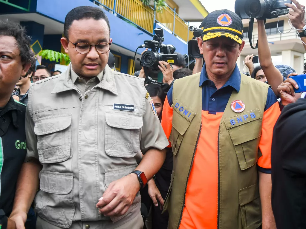 Gubernur DKI Anies Baswedan (kiri) ketika meninjau pintu air Manggarai, Jakarta, Kamis (2/1). Anies didesak mempercepat normalisasi Ciliwung agar banjir tidak terulang (Antara/Galih Pradipta).