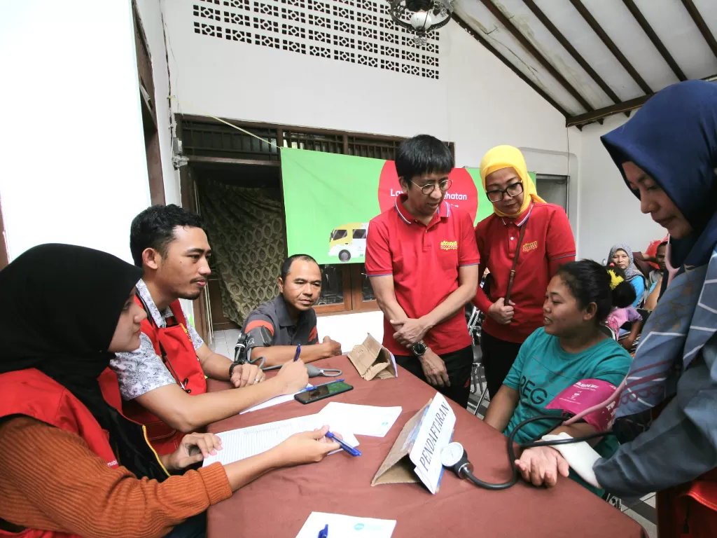 Chief Sales & Distribution Officer Indosat Ooredoo, Hendri Mulya Syam (tengah) saat turun ke posko banjir Pangadegan, Jakarta Selatan. (Dok. Indosat Ooredo)