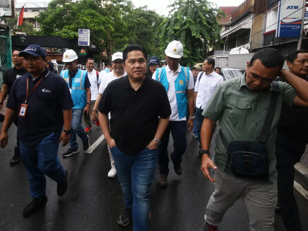 Menteri BUMN Erick Thohir (tengah) berjalan menuju tempat pengungsian korban banjir di Cengkareng, Jakarta, Minggu (5/1/2020). (photo/ANTARA/Rivan Awal Lingga)