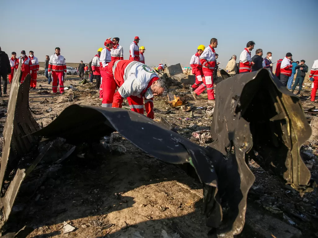  Tim penyelamat mengecek serpihan pesawat Boeing 737-800 milik Ukraine International Airline yang jatuh setelah lepas landas dari bandara Imam Khomeini, Teheran, Iran, Rabu (8/1/2020). photo/REUTERS/Wana News Agency