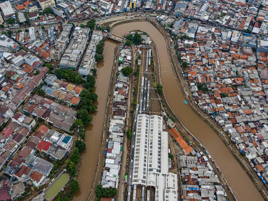 Foto udara suasana wilayah bantaran sungai Ciliwung yang belum dinormalisasi (kiri) dan yang sudah dinormalisasi (kanan) di kawasan Bukit Duri, Jakarta (Antara/Muhammad Adimaja)