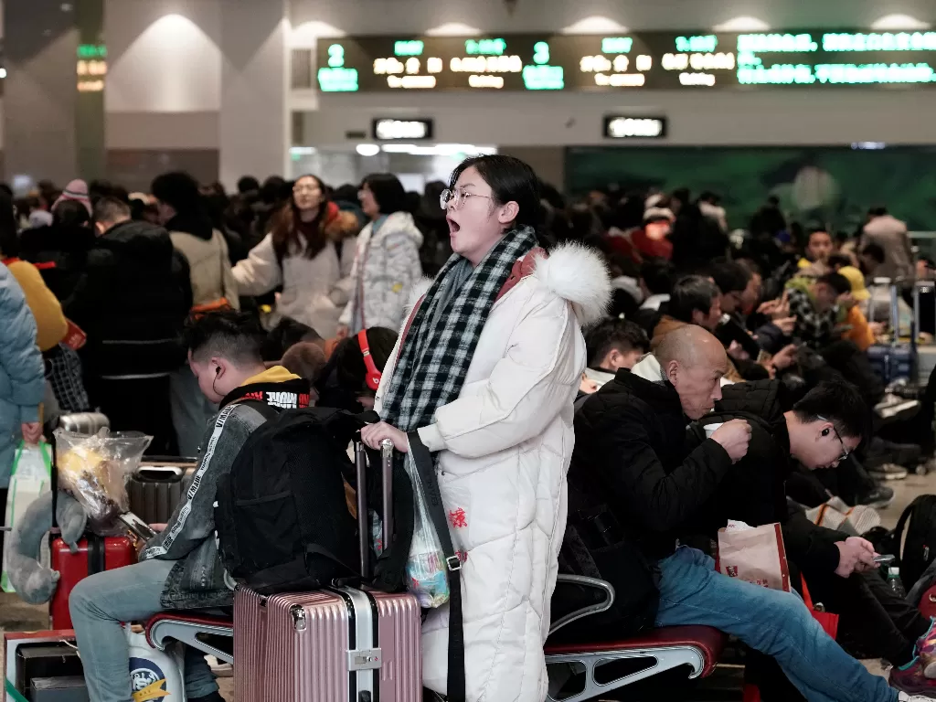 Seorang penumpang menunggu datangnya kereta untuk menuju kampung halamannya jelang perayaan Tahun Baru Imlek di Beijing, Tiongkok, Jumat (10/1/2020). (REUTERS/Jason Lee)